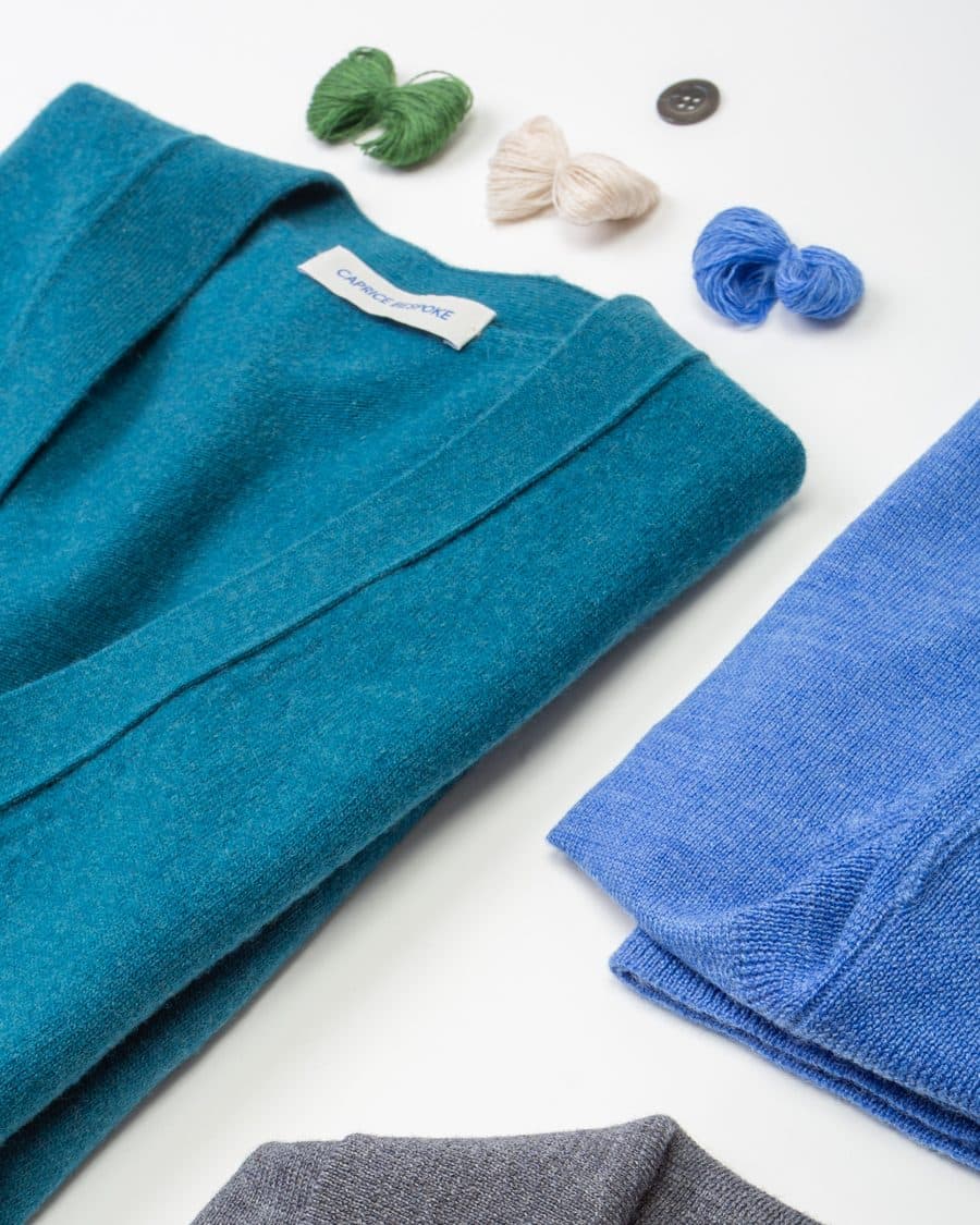 Teal and grey fine-gauge knitwear folded flat, produced in Italy to a brand specification