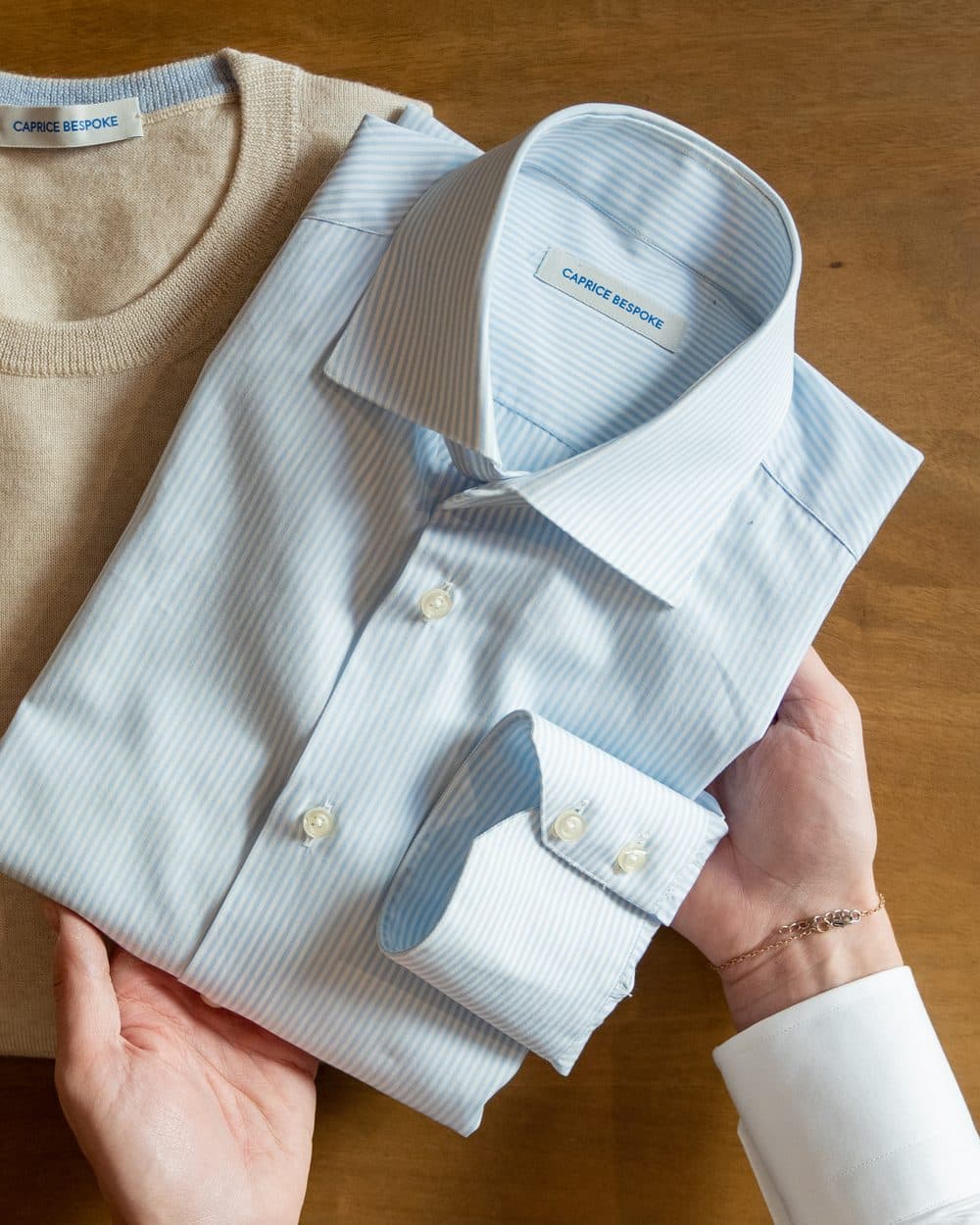 A close-up of a finished white shirt cuff and placket, cut and sewn in Italy to a brand specification