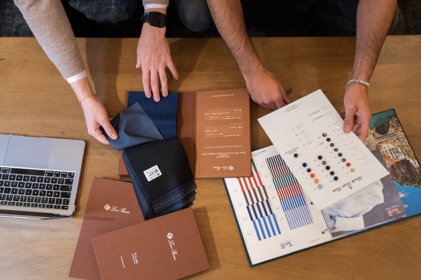 Production specification cards, fabric references and order paperwork laid out on a worktable
