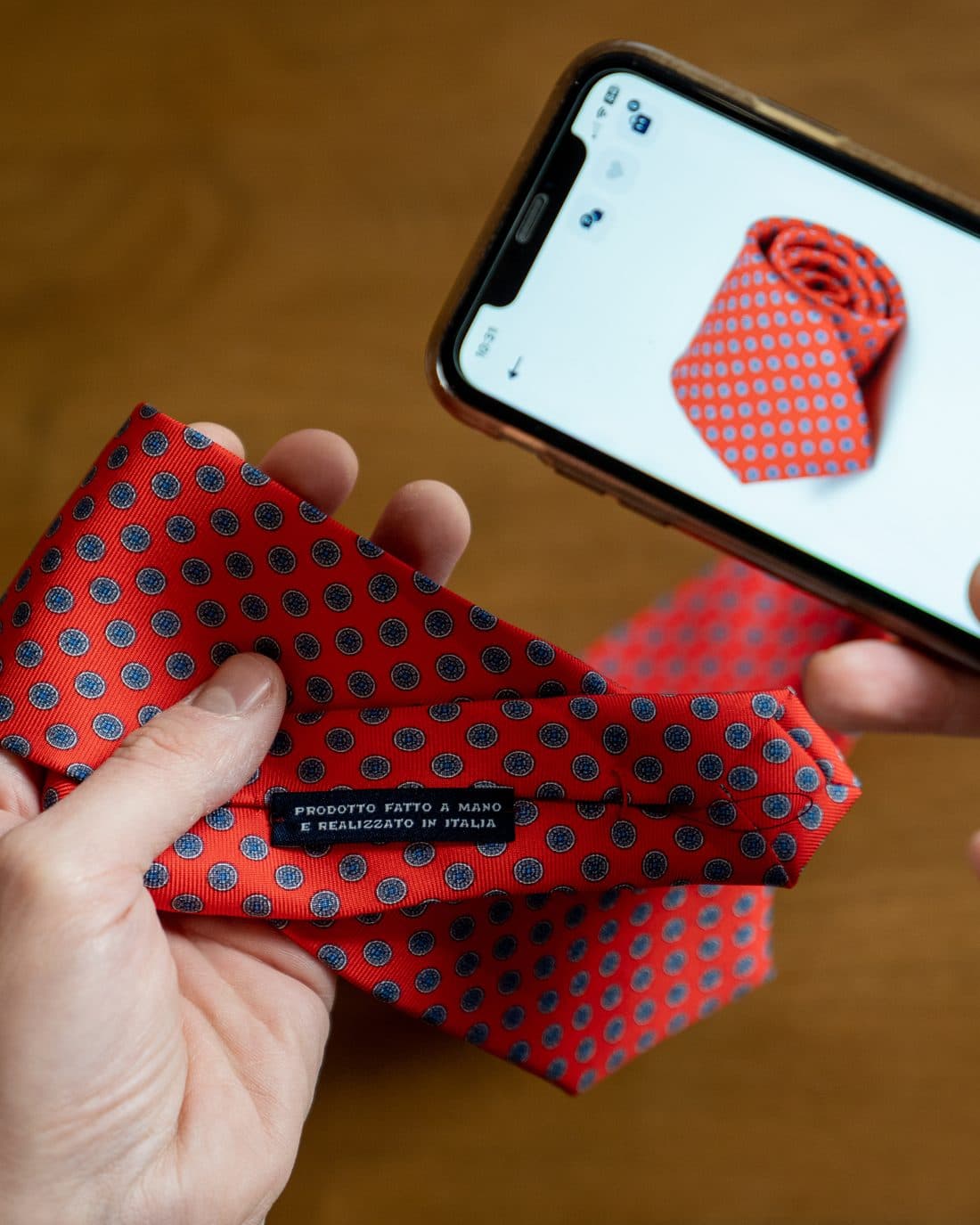 Silk cloth held beside a phone showing the same piece listed in a digital catalogue